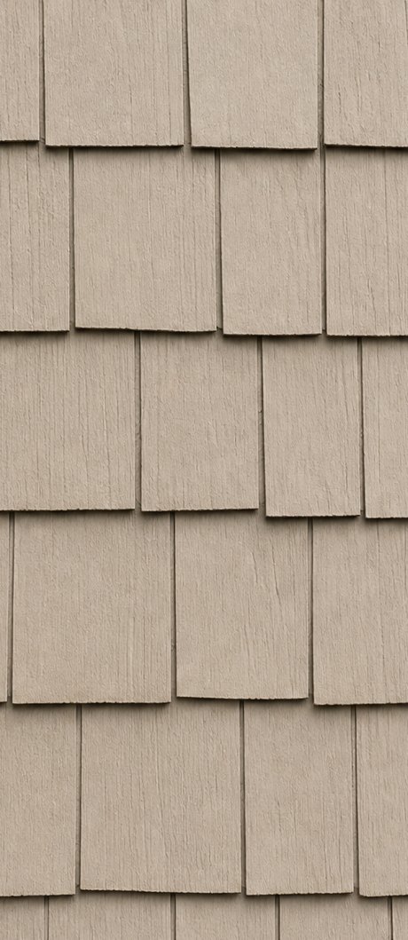Vinyl siding swatch in a shake profile — staggered hand-split cedar-shake tabs in horizontal courses.