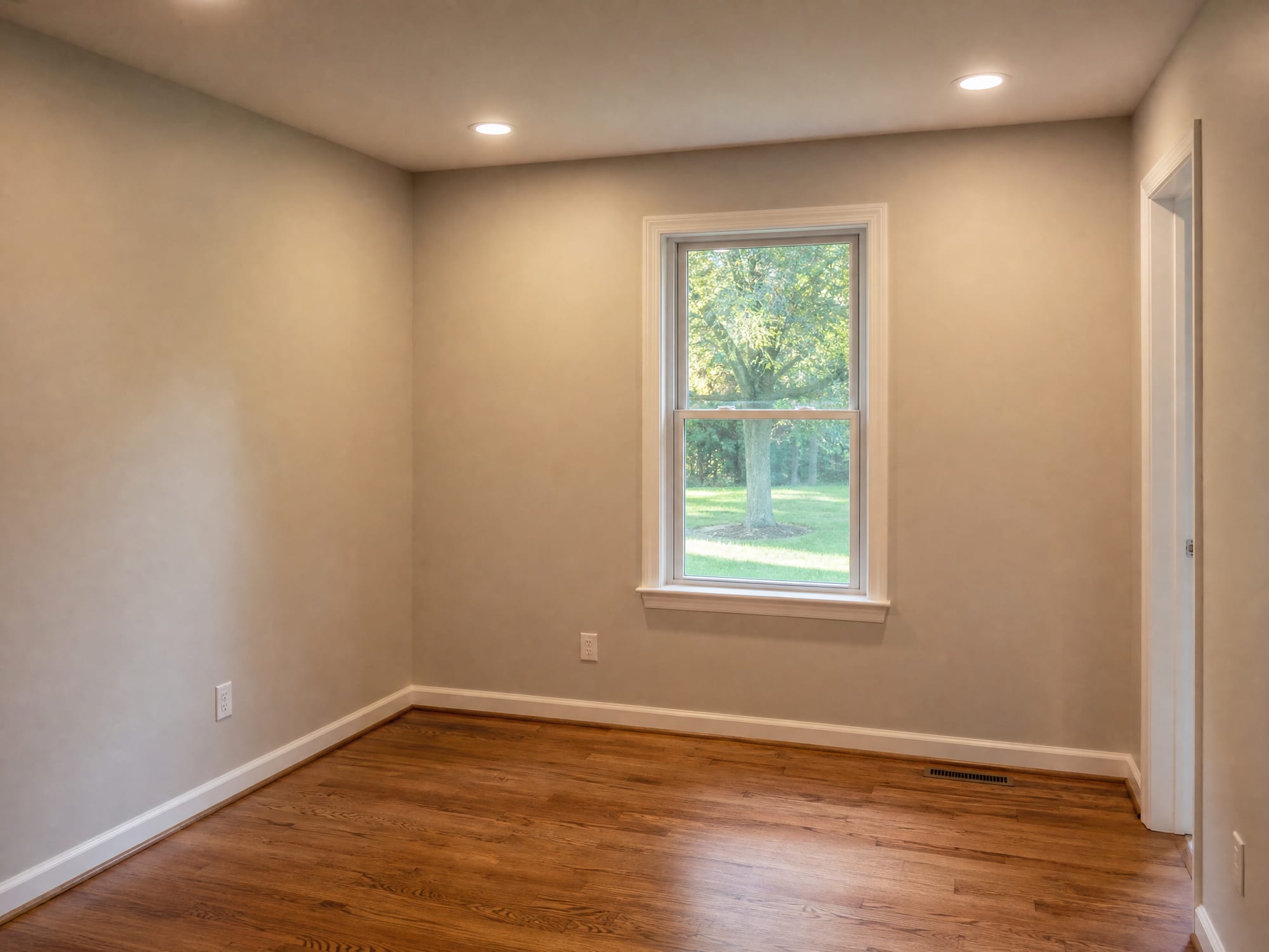 A solid-wall room addition with a single window and drywall, matching the home's siding