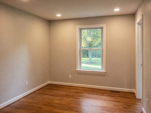 A solid-wall room addition with a single window and drywall, matching the home's siding