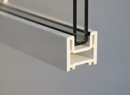 Corner cross-section of a white vinyl replacement window frame — a smooth, hollow, fusion-welded PVC profile